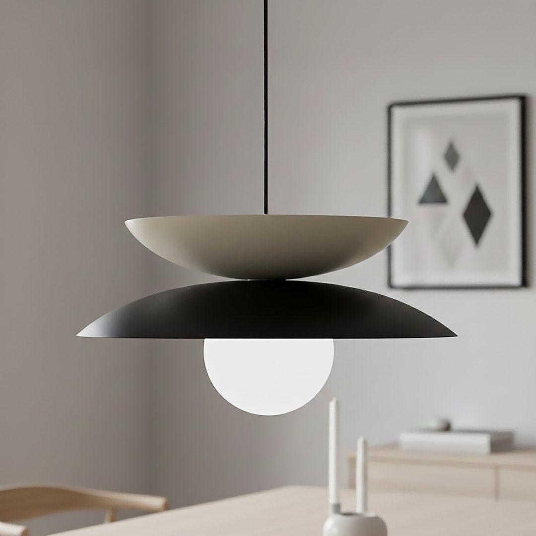 Vue de trois quarts du luminaire éclairé, coupelles beige et noire, verre opalin