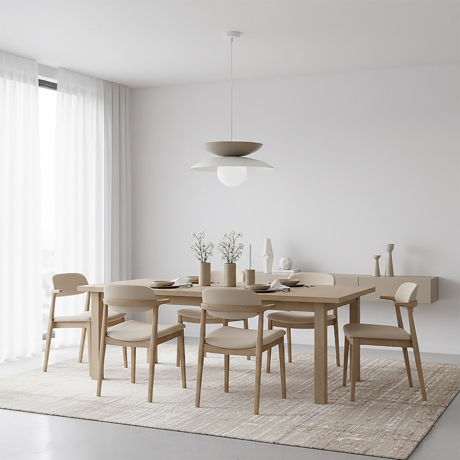 Vue d'ensemble d'une salle à manger où la suspension éclaire une table en bois clair