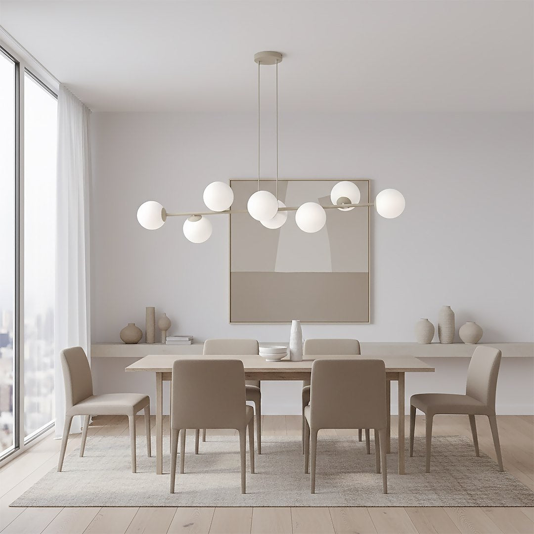 Suspension allumée au-dessus d'une table de salle à manger beige et blanche