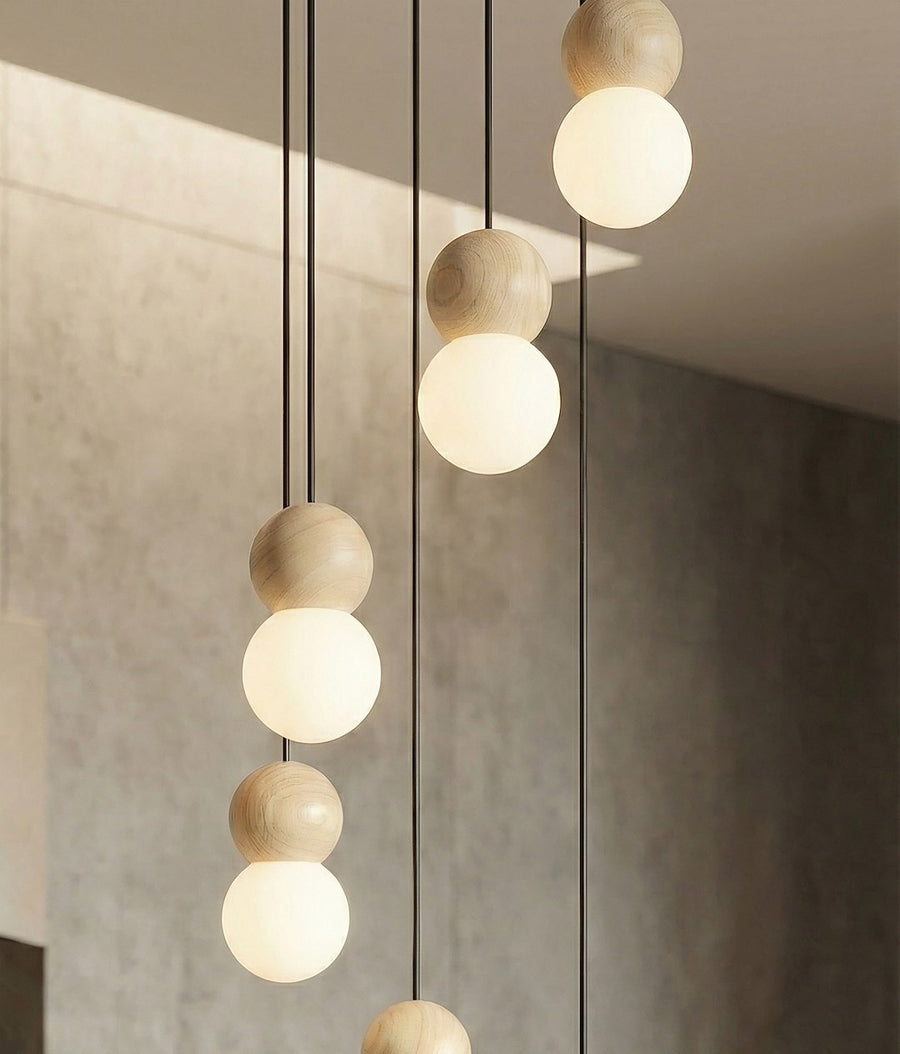Détail rapproché des sphères en bois clair surmontant les globes de verre opalin