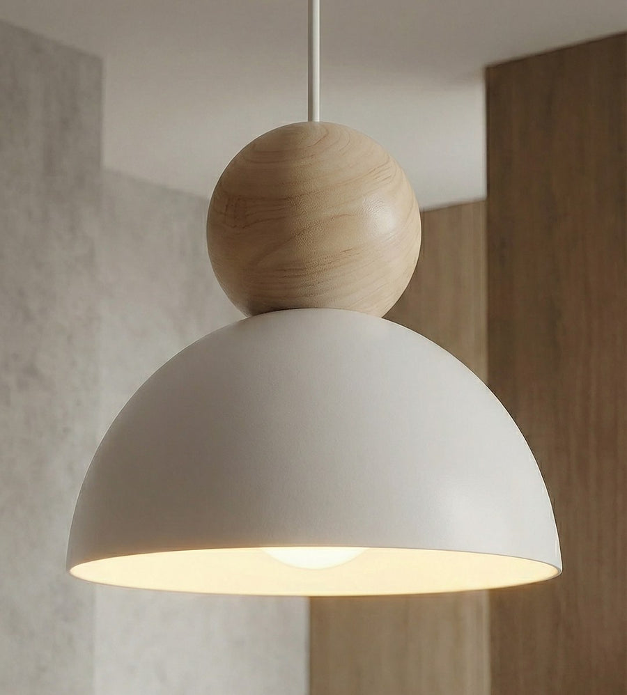 Détail d'une sphère en bois et d'un abat-jour blanc allumé.