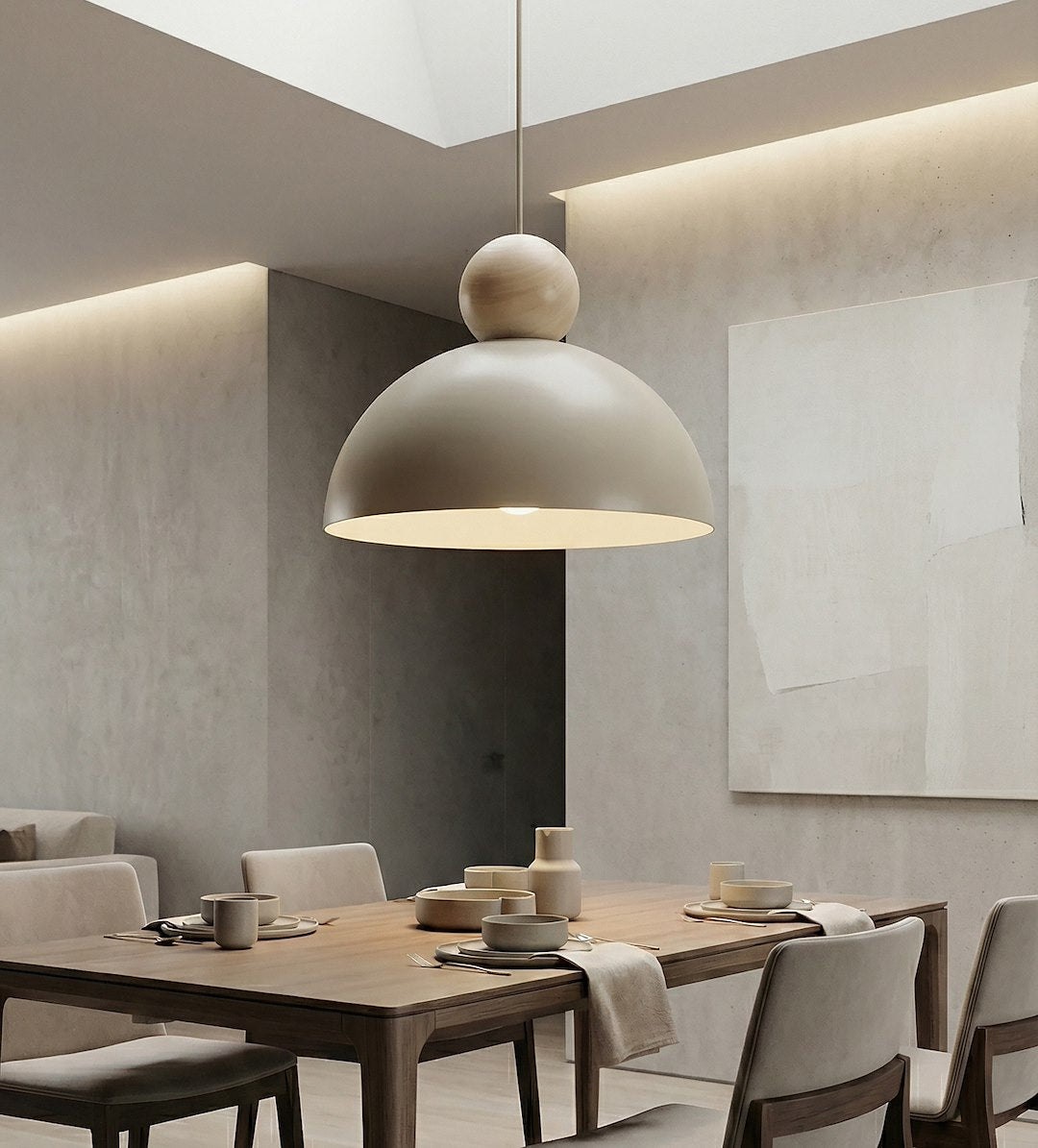 Mise en ambiance salle à manger, suspension allumée au-dessus d'une table en bois clair.