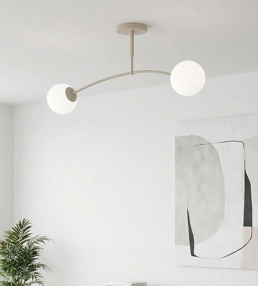 Mise en situation sur mur blanc, luminaire allumé près d'une grande toile encadrée