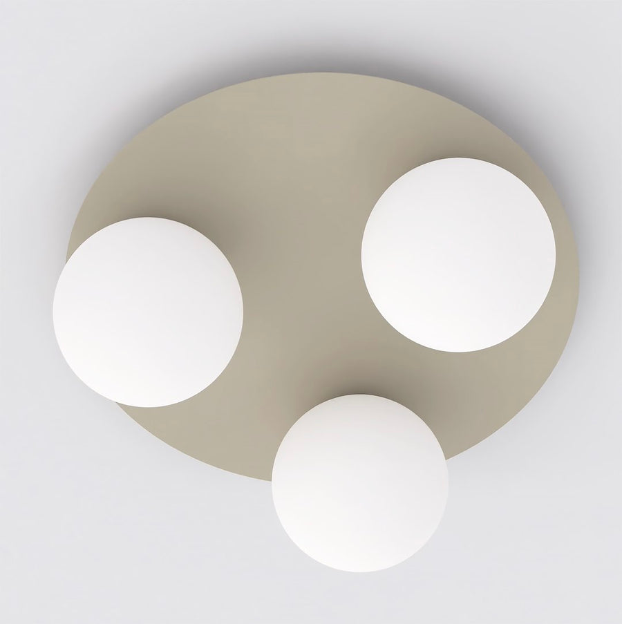 Vue de dessous montrant les trois sphères en verre blanc et le disque beige