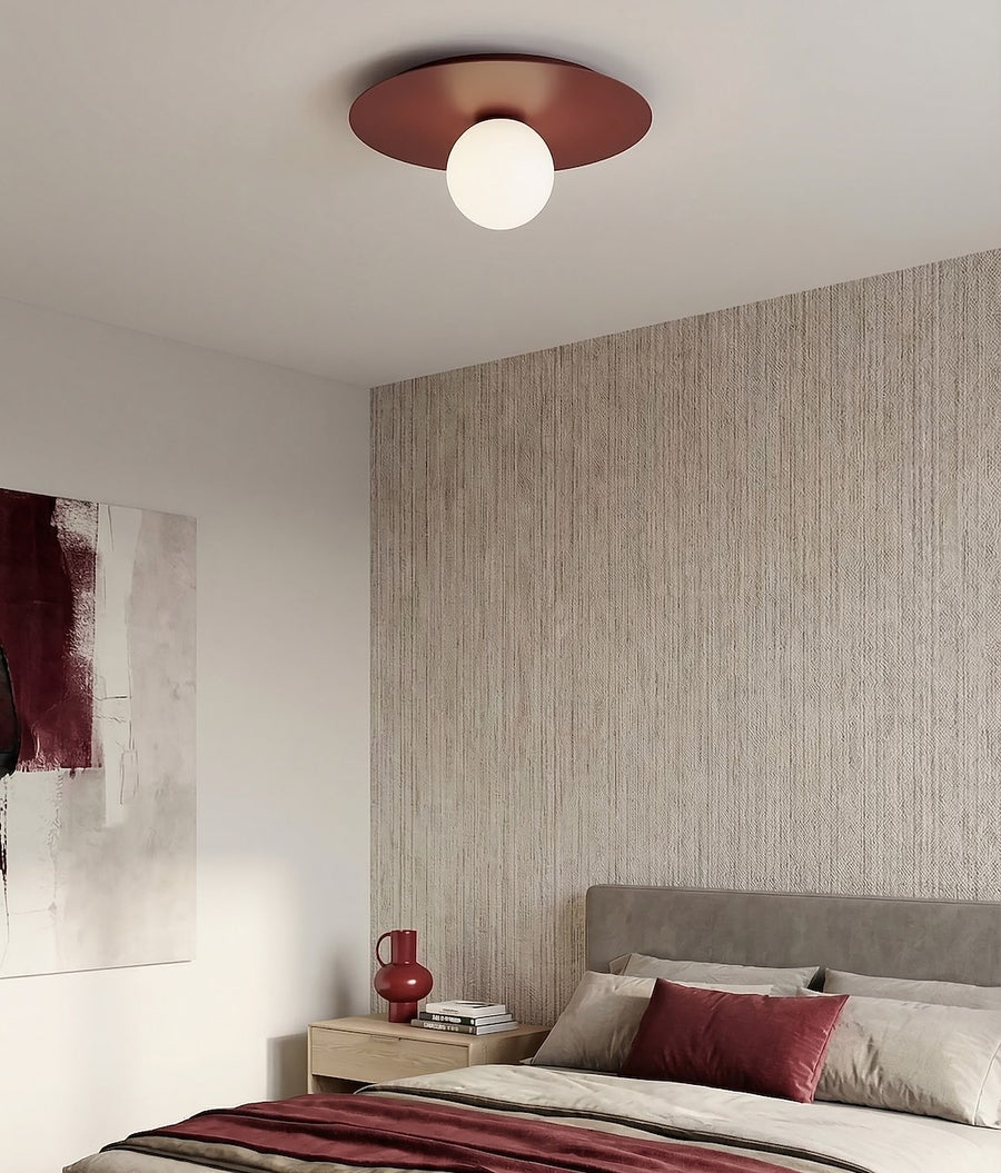 Plafonnier allumé dans une chambre au papier peint texturé beige