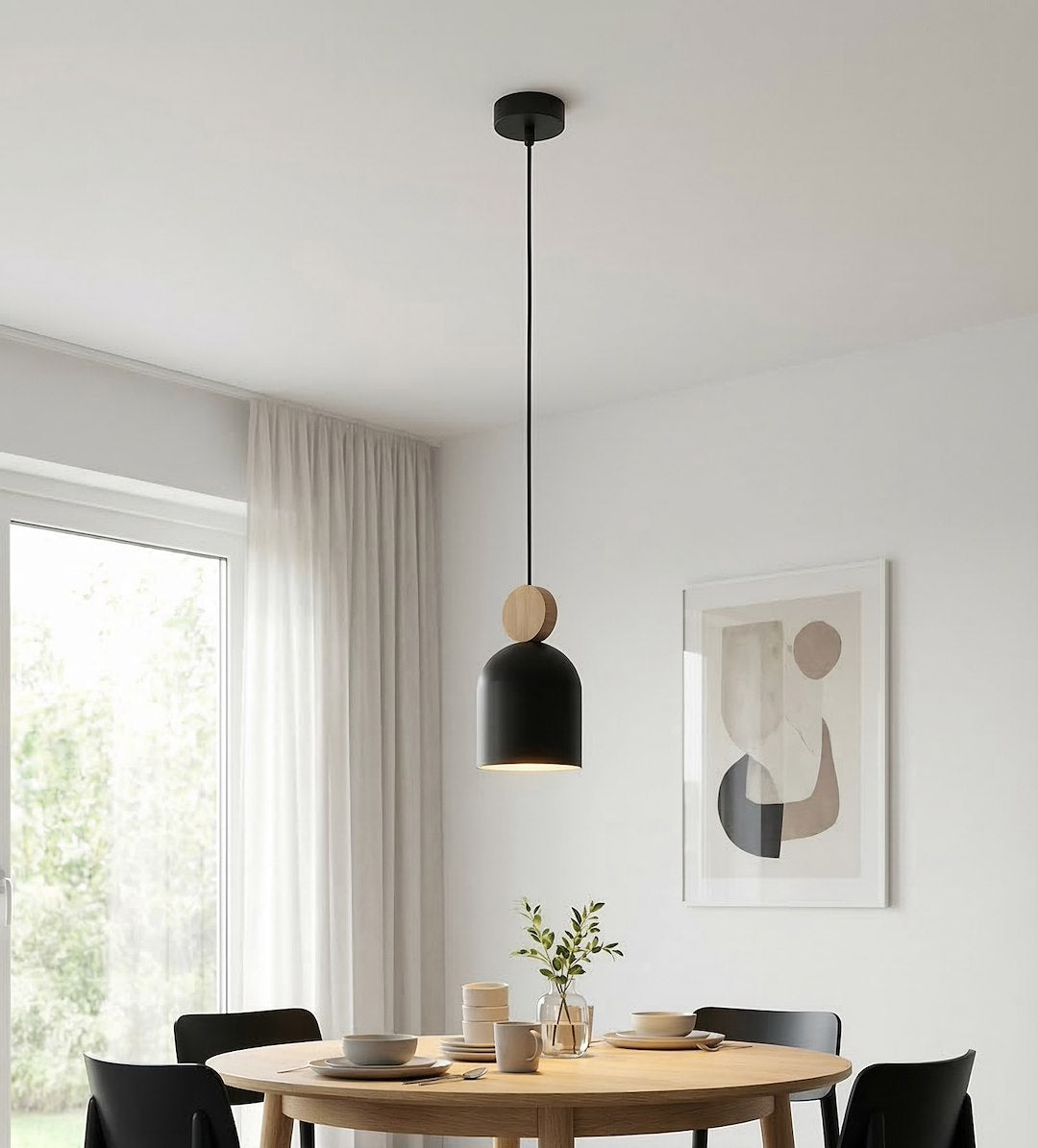 Mise en ambiance : suspension allumée au-dessus d'une table ronde en bois clair.