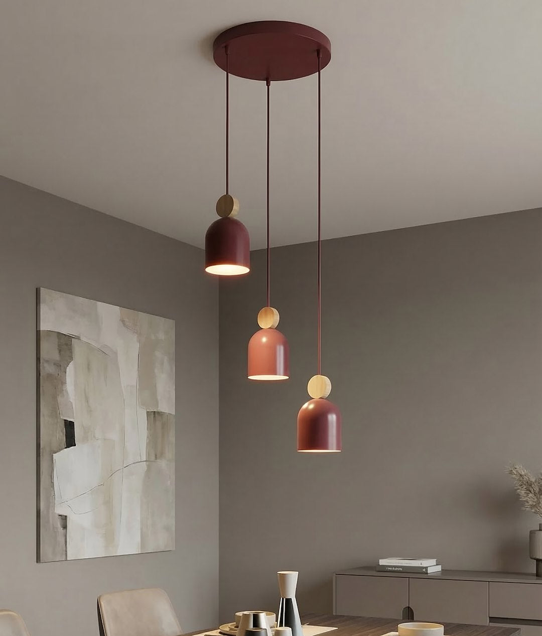 Mise en ambiance au-dessus d'une table, suspension bordeaux allumée dans un salon gris.