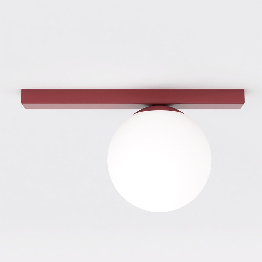 Vue de face du plafonnier rouge à diffuseur sphérique blanc sur fond neutre
