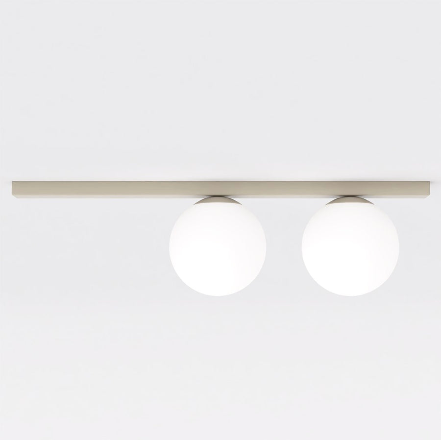 Vue de face : deux globes de verre blanc fixés sous une barre plate beige