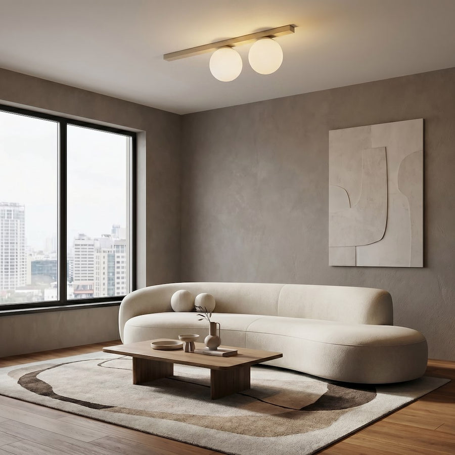 Plafonnier allumé dans un intérieur beige au-dessus d'un canapé arrondi
