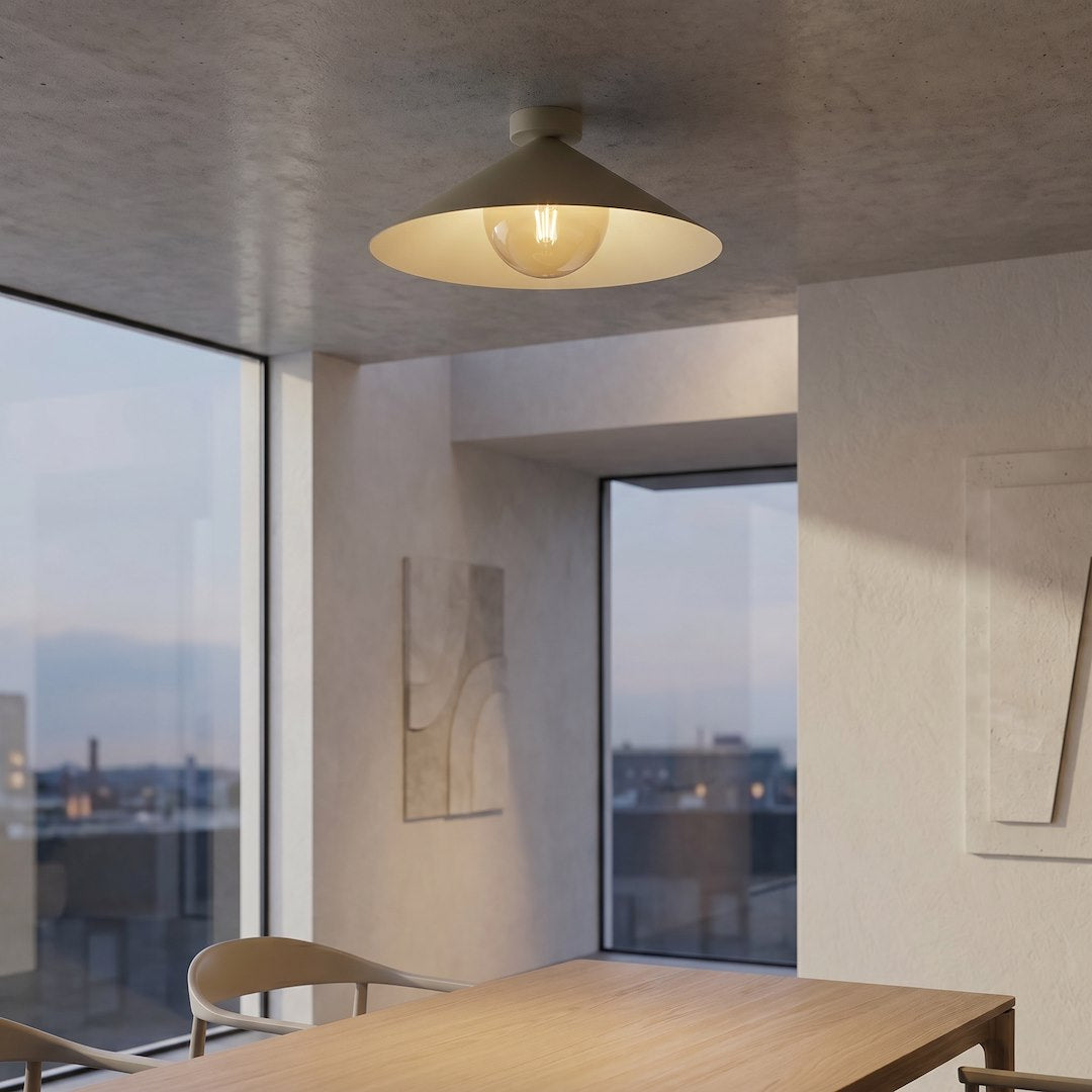 Plafonnier allumé au-dessus d'une table à manger, baies vitrées et vue nocturne.