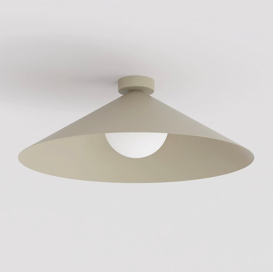 Vue en contre-plongée dévoilant le diffuseur rond en verre blanc opale sous l'abat-jour beige.
