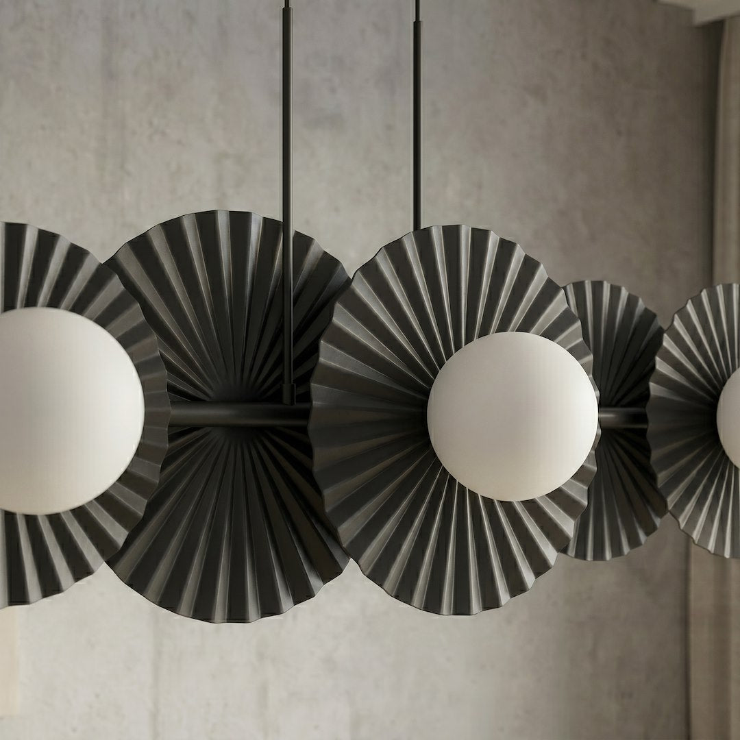Détail rapproché du métal plissé noir et des globes de verre opalin