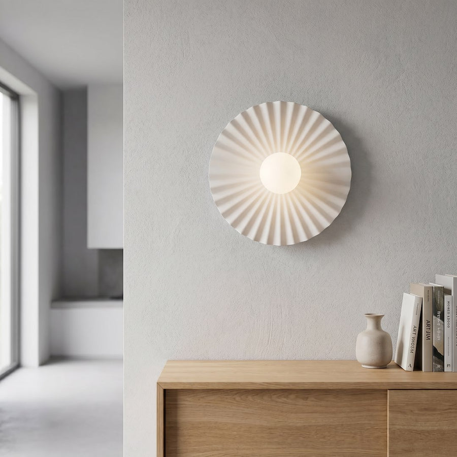 Applique allumée sur un mur gris clair au-dessus d'un meuble en bois