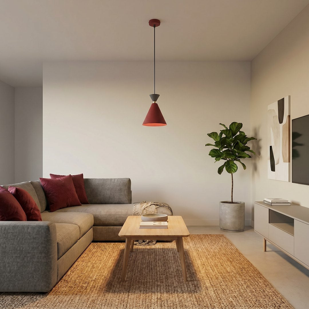 Mise en ambiance dans un salon beige, canapé, tapis et plante verte sous la suspension.
