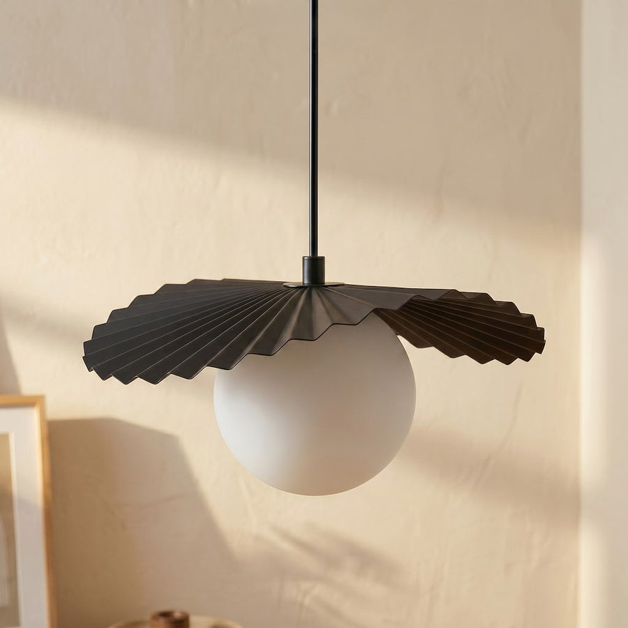 Gros plan sur un globe blanc surmonté d'une collerette noire plissée, mur beige