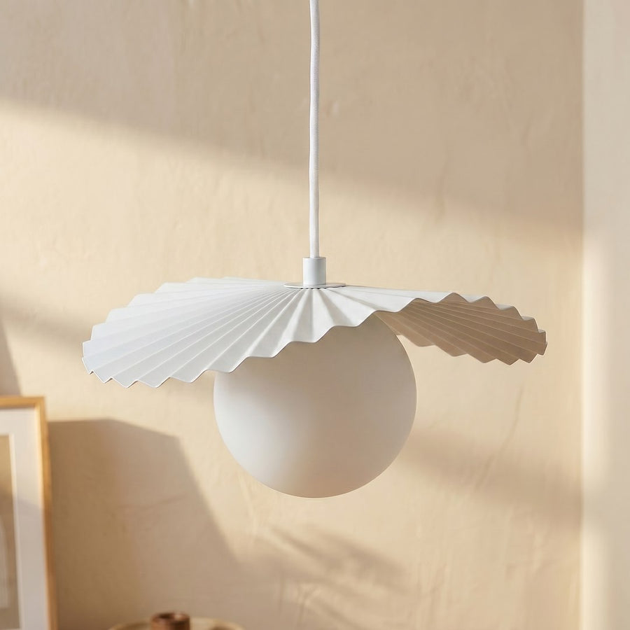 Détail rapproché d'une sphère en verre blanc et de sa collerette plissée façon origami