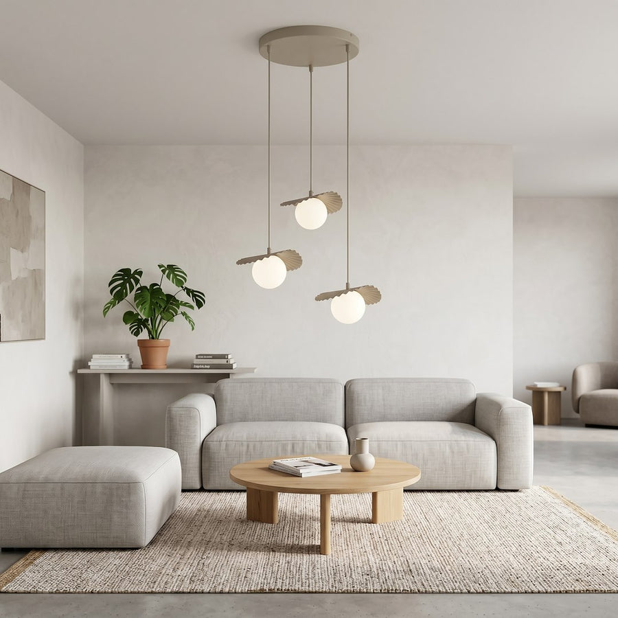 Scène de salon clair avec canapé gris, table basse et suspension allumée.