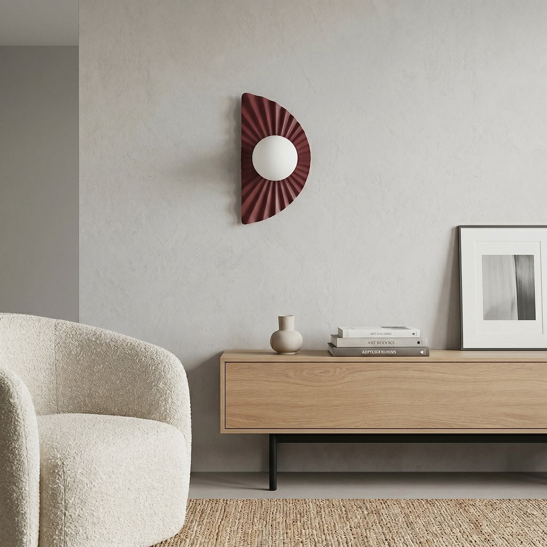 Vue d'ensemble d'un salon avec l'applique bordeaux fixée au mur et un canapé.