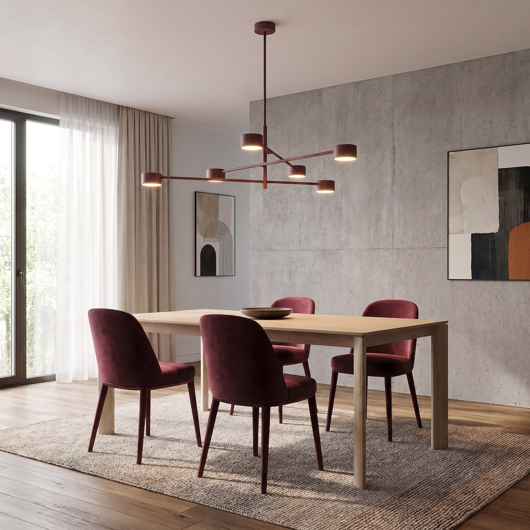 Salle à manger avec plafonnier bordeaux au-dessus table en bois et chaises velours