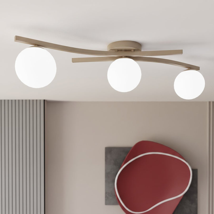 Plafonnier allumé au plafond, détail des trois globes lumineux blancs.