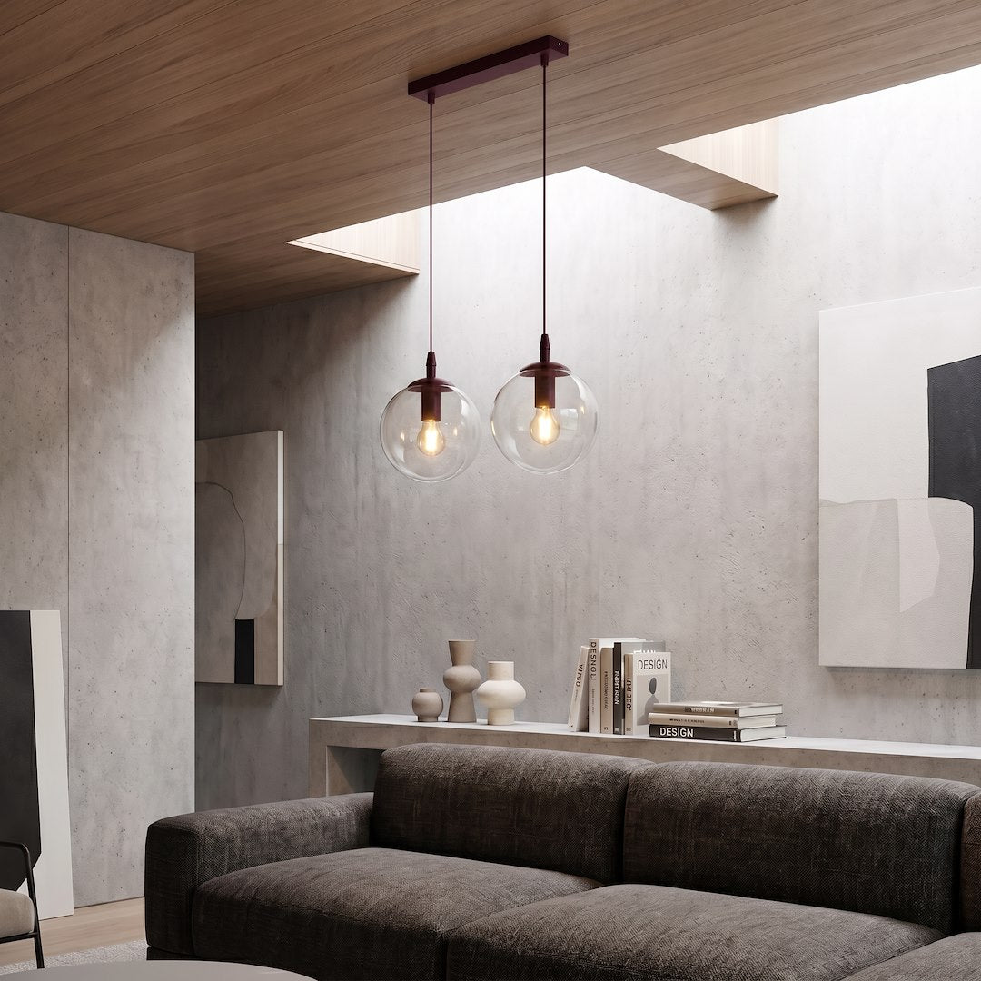 Mise en ambiance salon béton, suspension allumée au-dessus d'un canapé gris