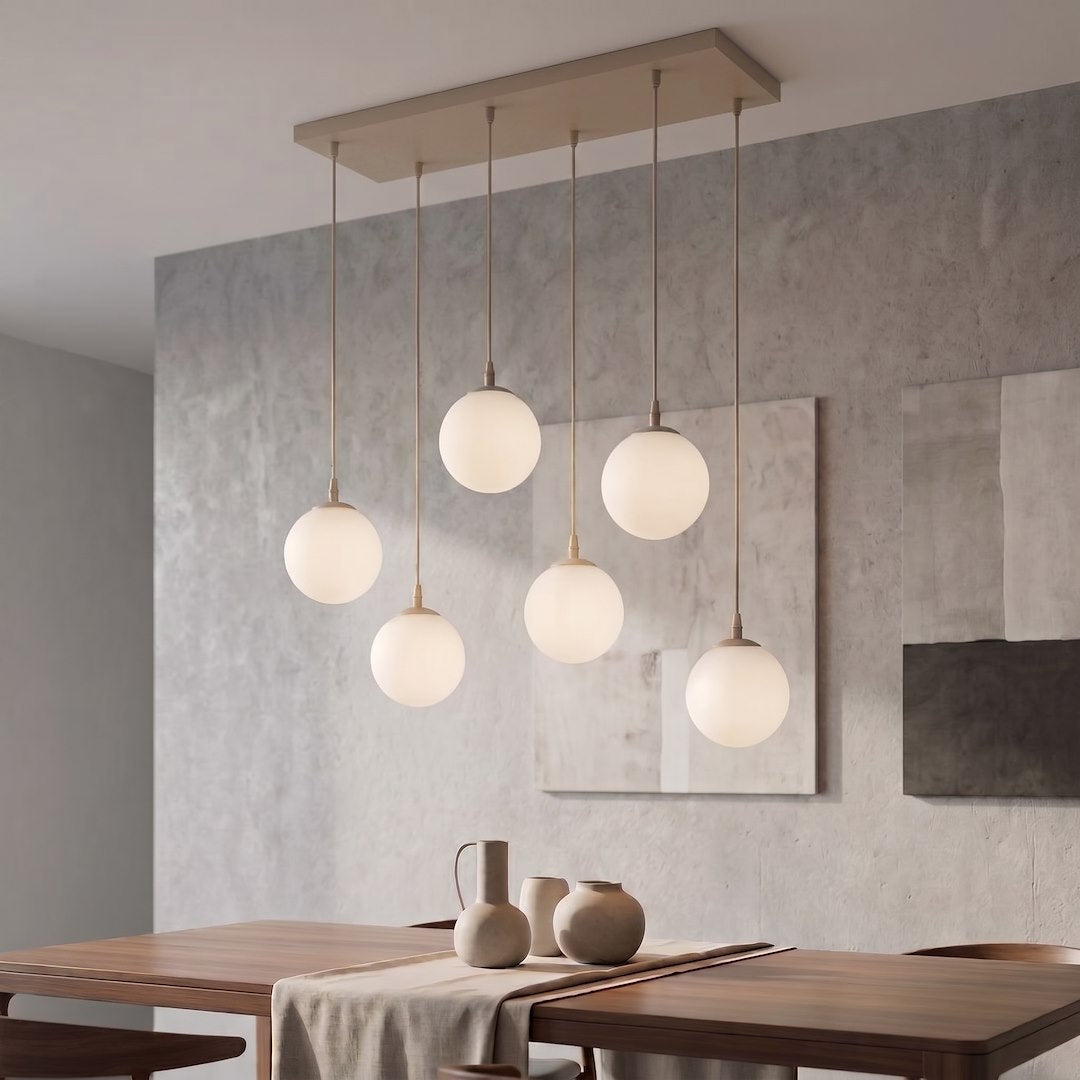 Suspension allumée dans un intérieur contemporain, mur béton et table en bois