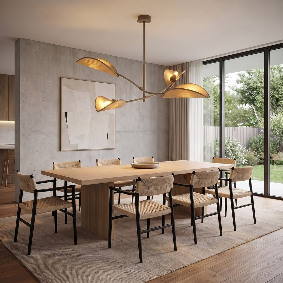 Luminaire suspendu allumé au-dessus d'une table en bois, chaises tressées, salle à manger