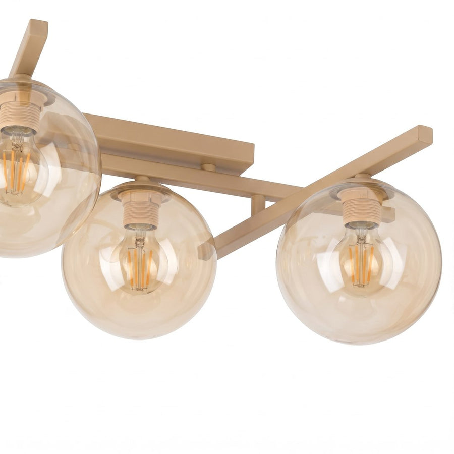 Détail des globes en verre ambré et douilles beige sur bras métalliques.