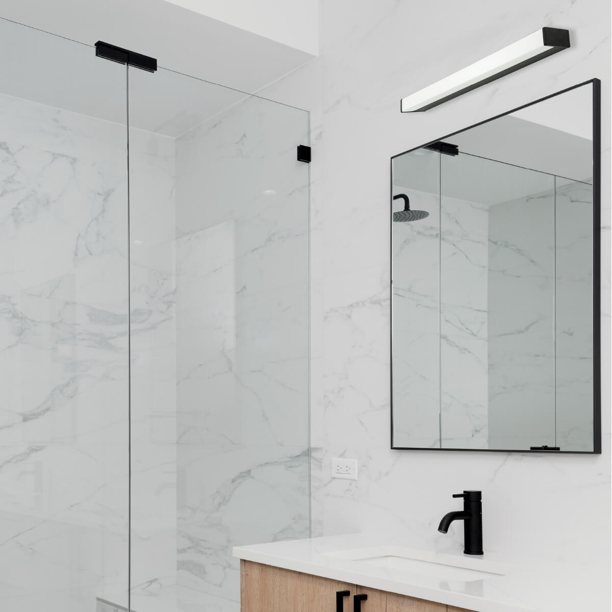 Vue rapprochée du luminaire éclairé devant une douche vitrée et du marbre blanc
