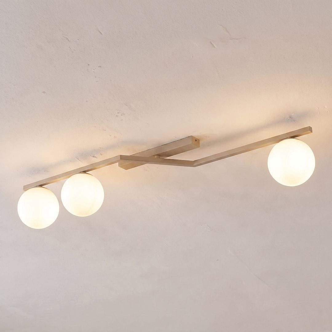 Vue du dessous montrant les trois globes allumés diffusant une lumière chaude