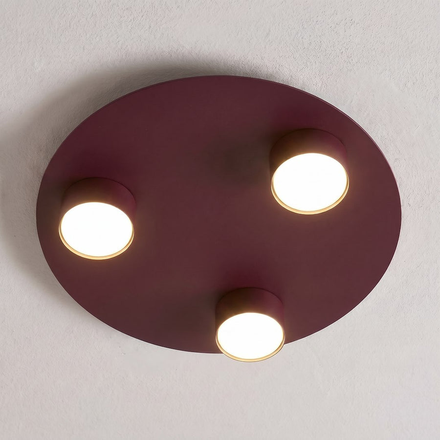 Luminaire fixé au plafond blanc, allumé, diffusant une lumière chaude dans la pièce.