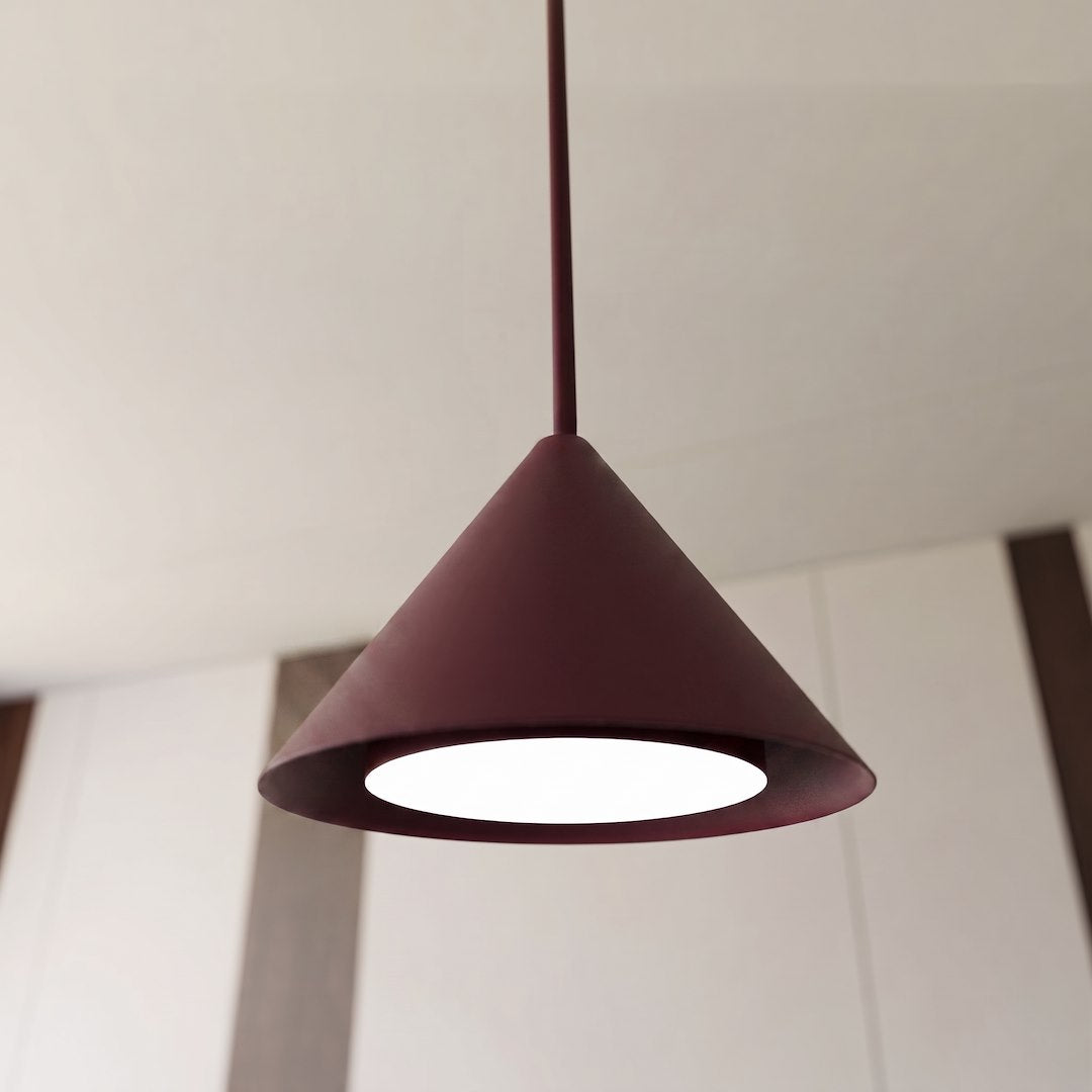 Gros plan sur un abat-jour conique bordeaux allumé avec diffuseur blanc intégré