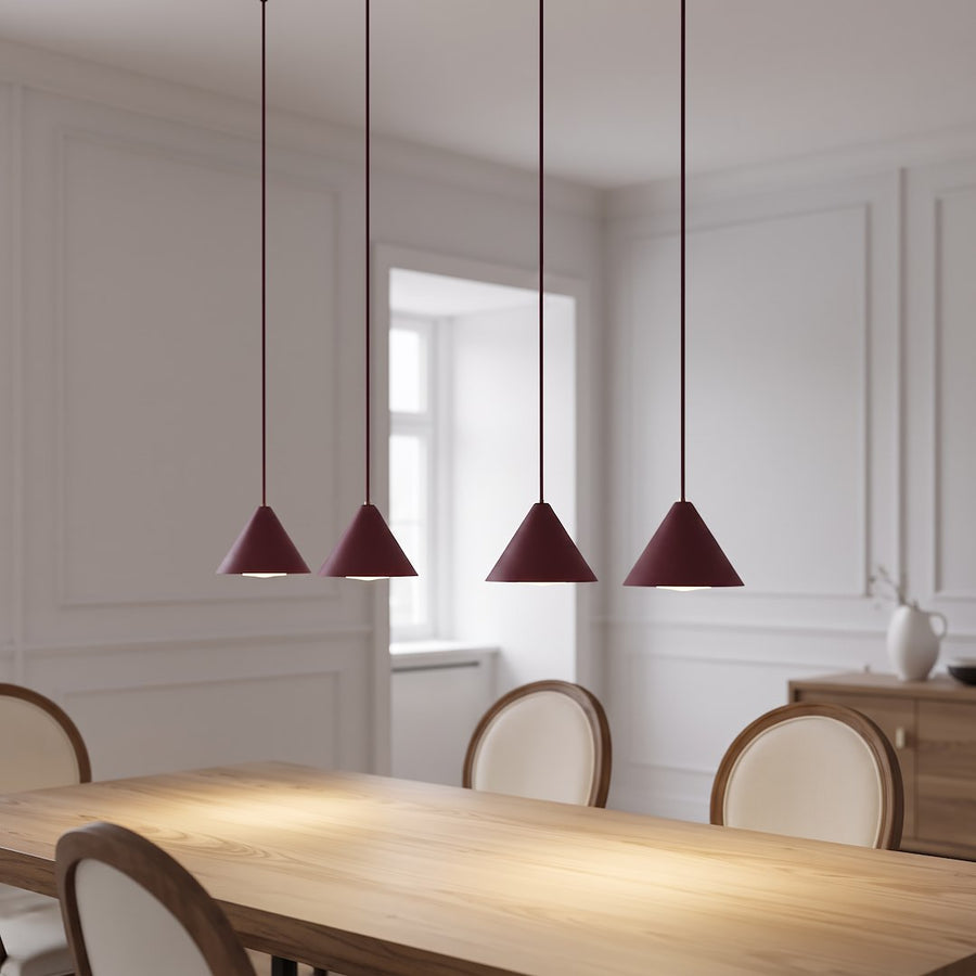 Suspension allumée au-dessus d'une table en bois dans une salle à manger blanche moulurée
