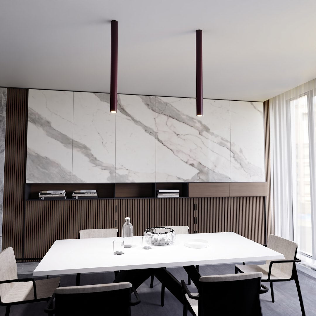 Deux tubes bordeaux suspendus au-dessus d'une table blanche en salle à manger