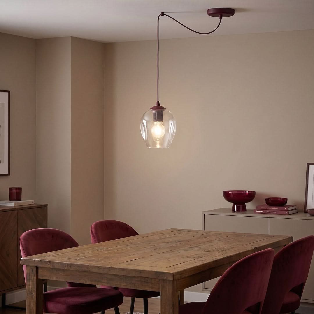 Mise en ambiance au-dessus d'une table à manger en bois avec chaises velours bordeaux