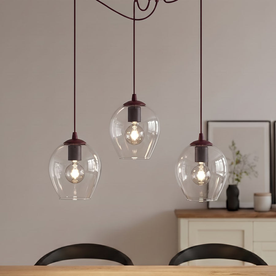 Détail rapproché des trois globes en verre transparent et douilles bordeaux