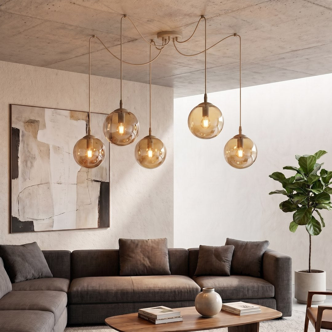 Mise en ambiance salon, luminaire allumé au-dessus d'un canapé gris et d'une toile