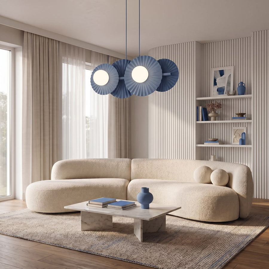 Luminaire suspendu bleu éclairant un salon avec canapé beige et table basse.