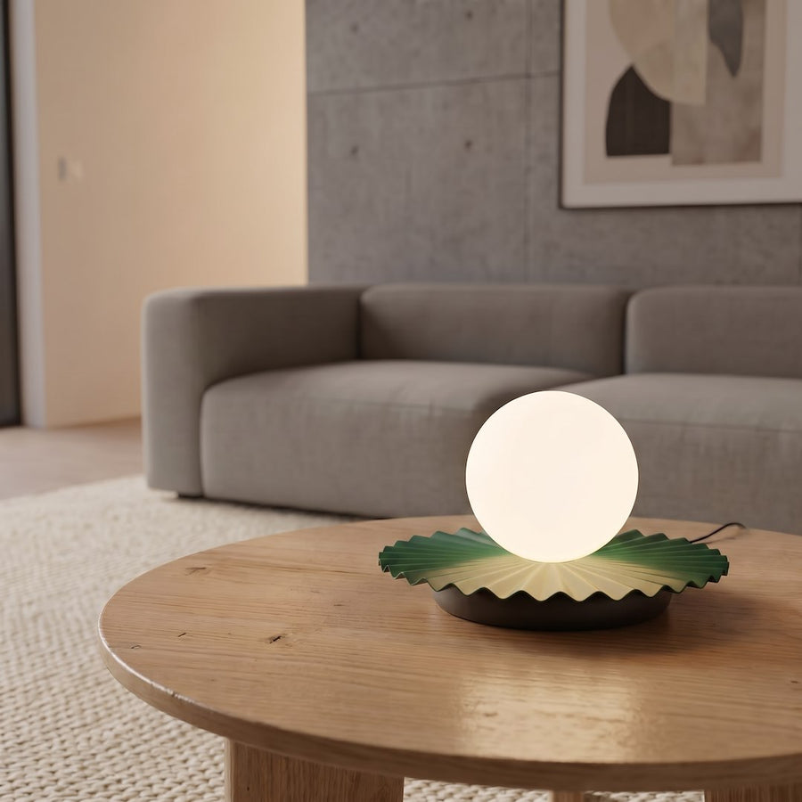 Lampe allumée posée sur table basse en bois, canapé gris en arrière-plan.