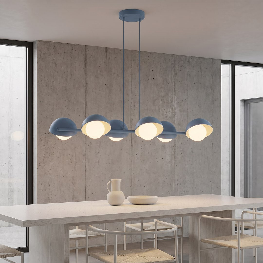 Suspension allumée au-dessus d'une table en bois devant un mur béton