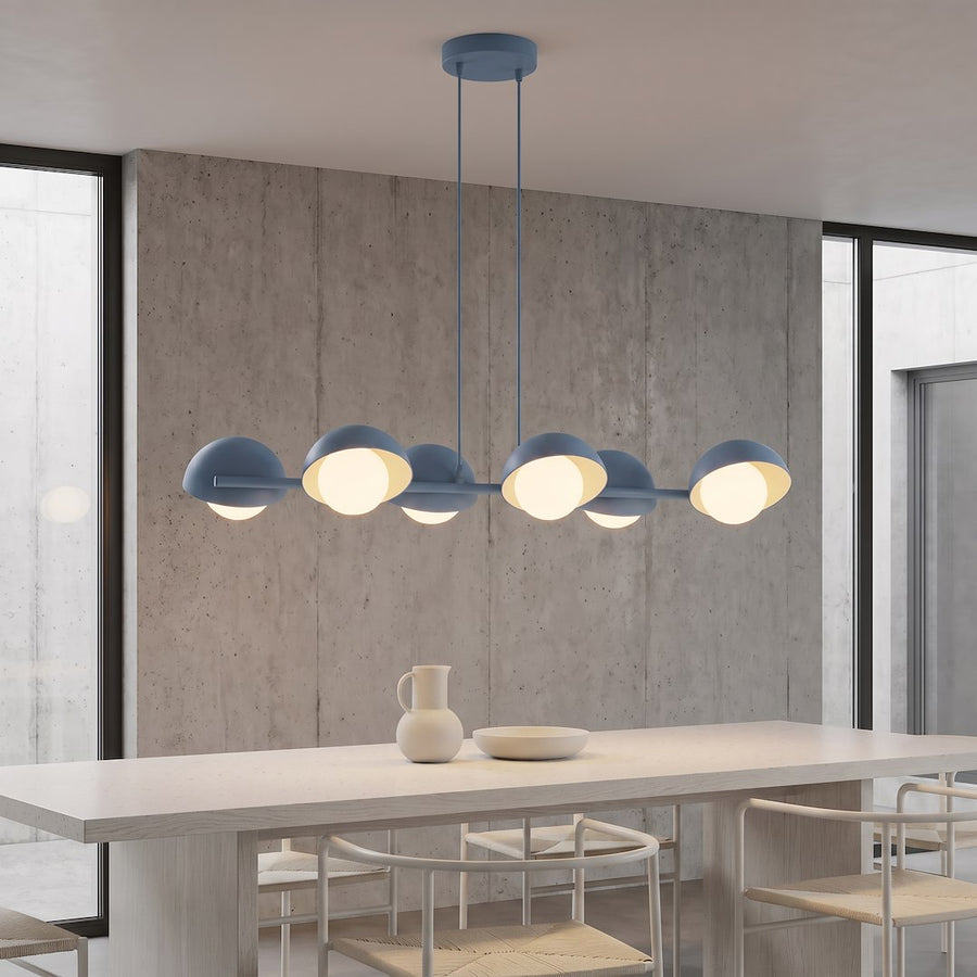 Suspension allumée au-dessus d'une table en bois devant un mur béton
