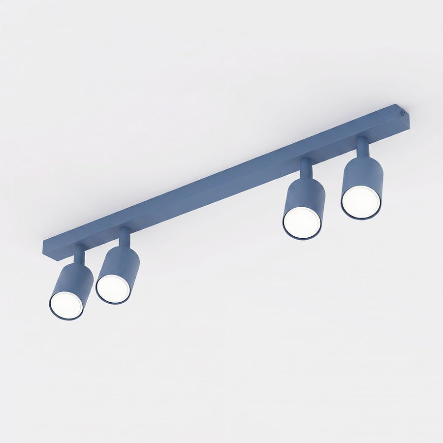 Luminaire bleu vu de trois quarts sur fond blanc, quatre spots cylindriques orientables