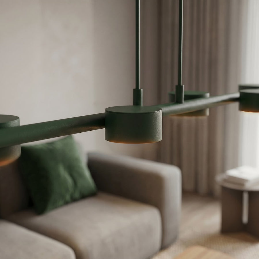 Détail rapproché de la finition vert mat et de la lumière chaude sous les spots