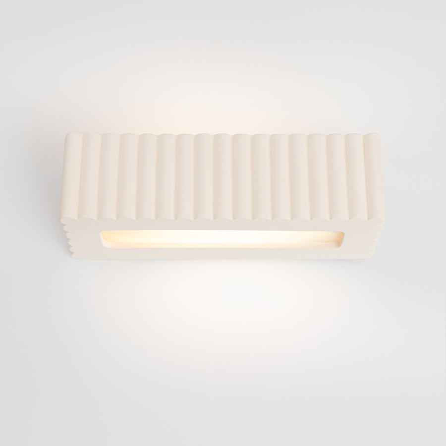 Vue frontale à plat, bandeau LED lumineux sous la coque céramique cannelée.