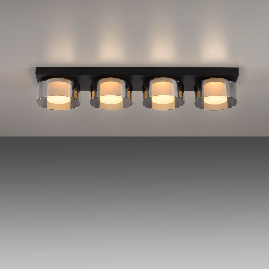 Plafonnier allumé au plafond sur fond gris, diffusant une lumière chaude en halo