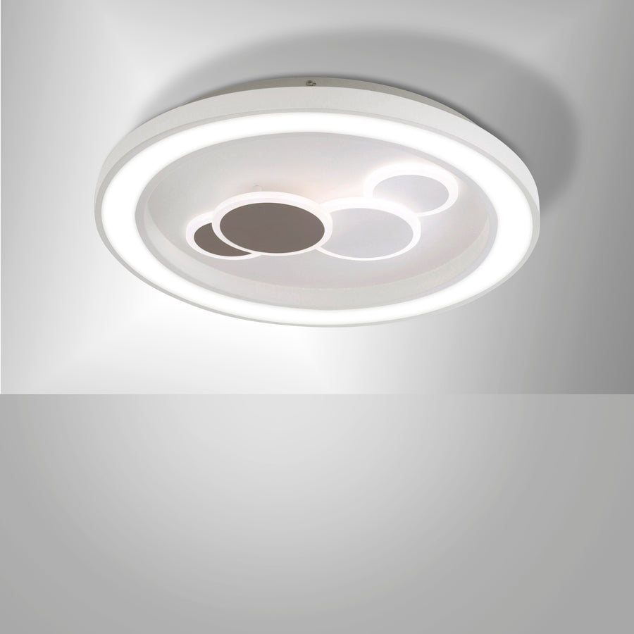Vue de détail du luminaire blanc allumé, anneau LED et formes centrales en relief.