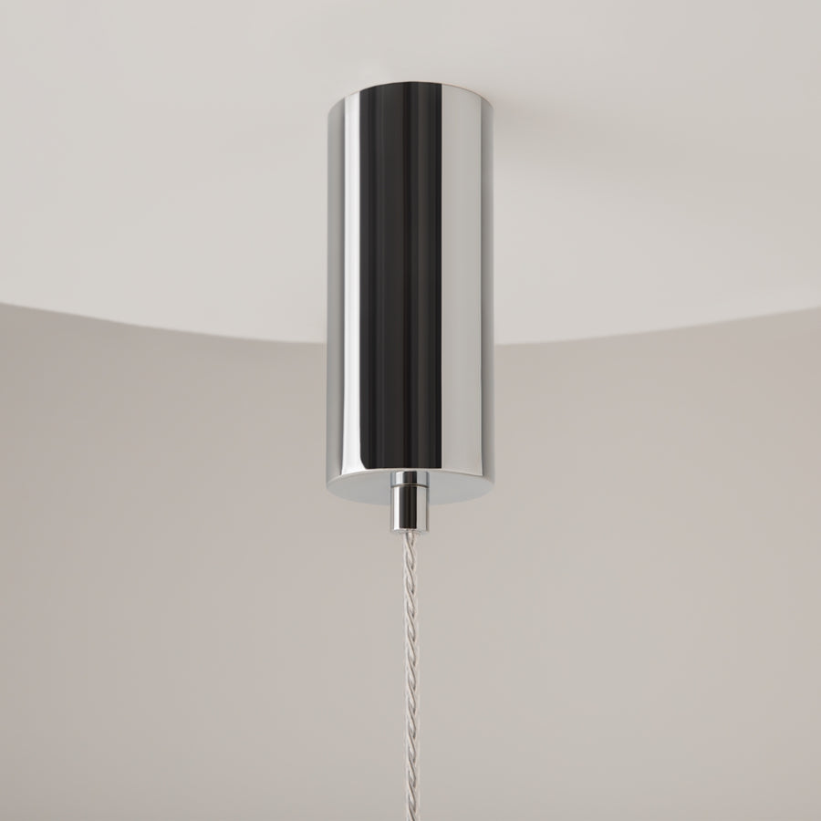 Détail du pavillon cylindrique chromé fixé au plafond et du câble