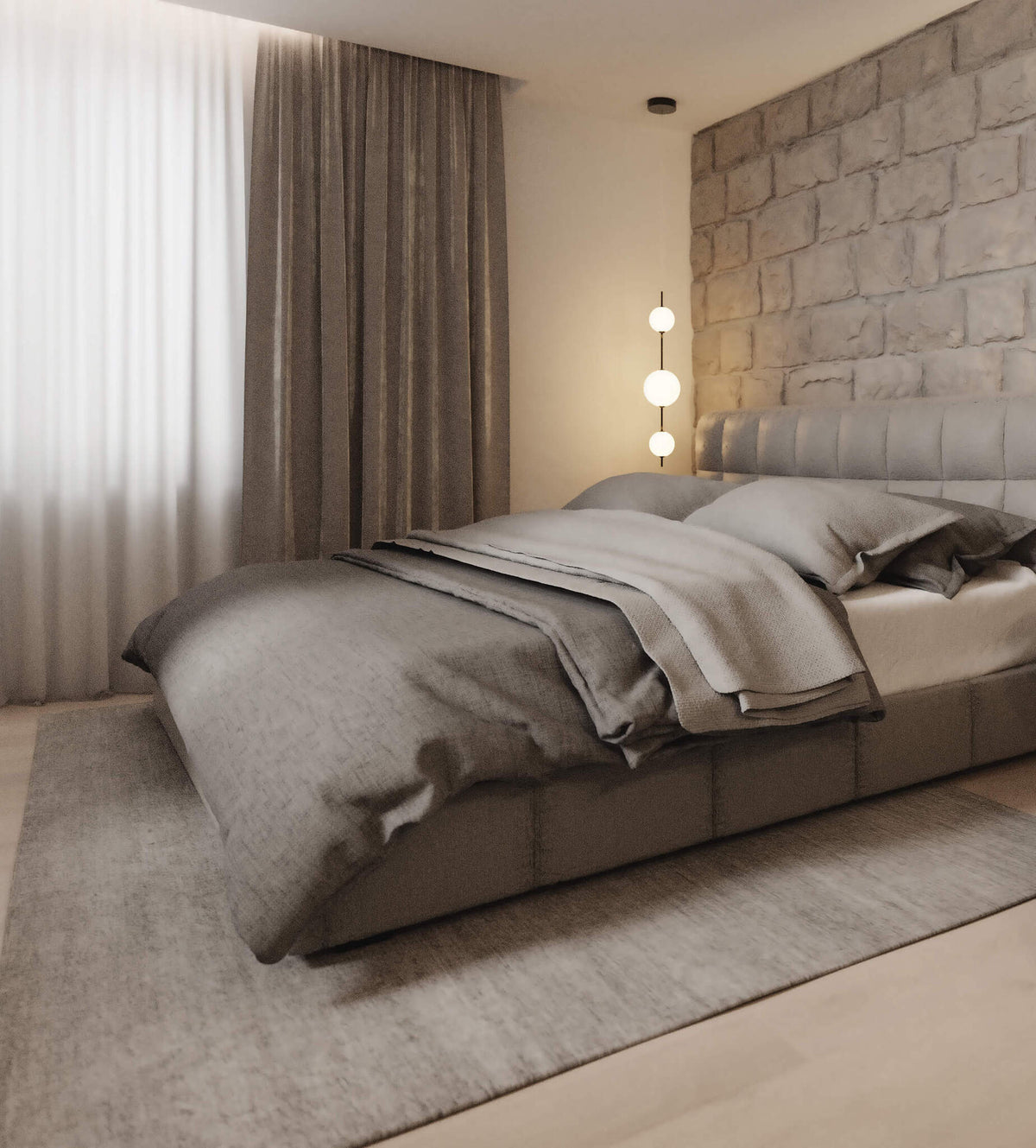 Chambre complète avec suspension allumée, rideaux, lit gris et mur en pierre.