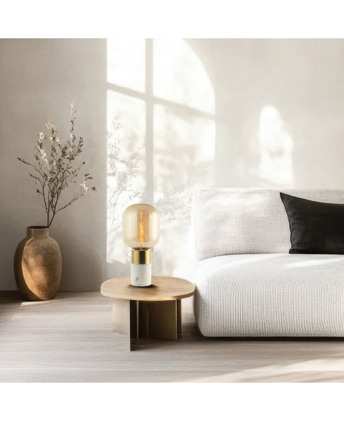 Intérieur épuré, lampe en verre ambré allumée sur table ronde, lumière naturelle traversante